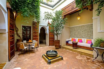 a courtyard with a bed and a table and chairs at Riad 92 - Architect's Riad in the Exclusive Dar El Bacha in Marrakech
