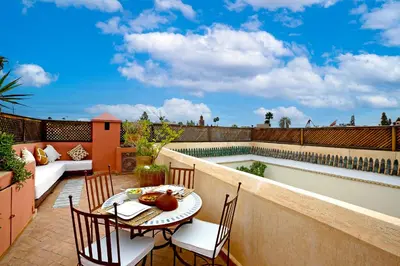 a patio with a table and chairs next to a swimming pool at Riad 92 - Architect's Riad in the Exclusive Dar El Bacha in Marrakech