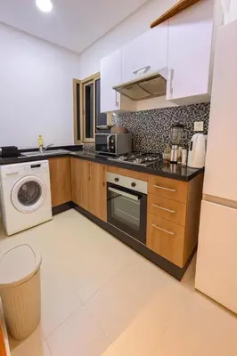 a kitchen with a stove and a microwave at Appartement de luxe prestigia Golf Resort in Marrakech