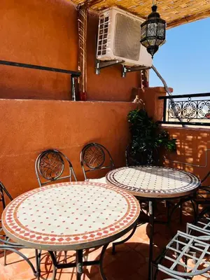 two tables and chairs sitting on a patio at Riad MS holidays terrasse privatisé Marrakech in Marrakech