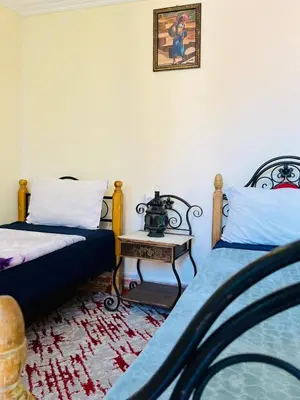a room with two beds and a side table at Riad MS holidays terrasse privatisé Marrakech in Marrakech