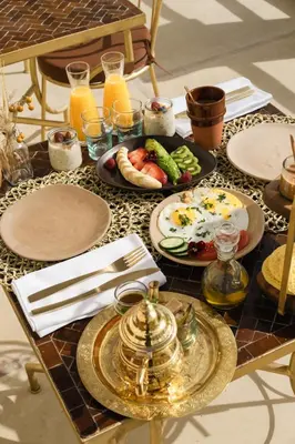 a table with plates of food and glasses of orange juice at Riad Rahal in Marrakech