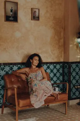 a woman sitting on a couch in a room at Kenzara Suites & Pool, Your private escape in Marrakech