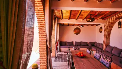 a dining room with a table and a couch at Riad RIM in Marrakech