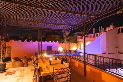 a room with a table on a balcony with purple lighting at Riad RIM in Marrakech
