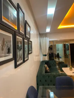 a living room with a green couch and pictures on the wall at Oasi Marrakech in Marrakech