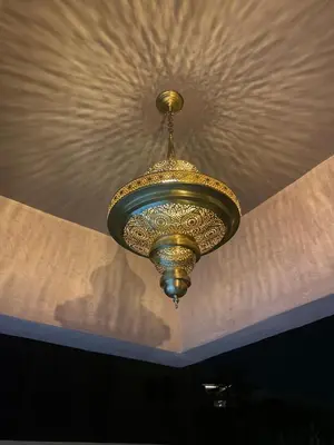 a gold chandelier hanging from a ceiling at Oasi Marrakech in Marrakech