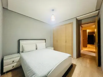 a bedroom with a white bed and a window at Corail Apart Golfique -Prestigia in Marrakech