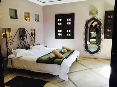 a bedroom with a large bed and a mirror at Le Havre de paix in Marrakech