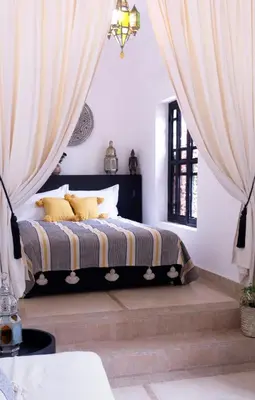 a bedroom with a bed with yellow pillows at Riad Al Wifak in Marrakech