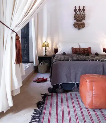 a bedroom with a bed and a red rug at Riad Al Wifak in Marrakech