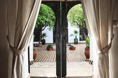 an open door to a courtyard with potted plants at Riad Al Wifak in Marrakech