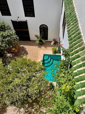 a backyard with a swimming pool and some plants at Riad Al Wifak in Marrakech
