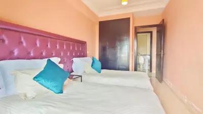 two beds with blue pillows in a bedroom at Résidence Anas Majorelle -Centre Ville in Marrakech