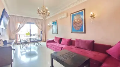 a living room with a red couch and a table at Résidence Anas Majorelle -Centre Ville in Marrakech
