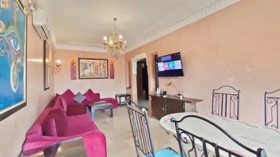 a living room with pink furniture and a dining room at Résidence Anas Majorelle -Centre Ville in Marrakech