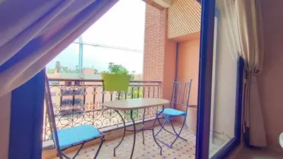 a balcony with a table and chairs on a balcony at Résidence Anas Majorelle -Centre Ville in Marrakech