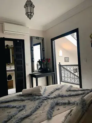a bedroom with a bed and a large mirror at Riad Darnooz Marrakech in Marrakech