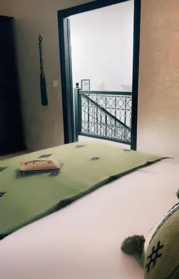a bedroom with a bed with a view of a balcony at Riad Darnooz Marrakech in Marrakech
