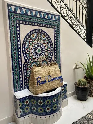 a staircase with a tile wall with a purse on it at Riad Darnooz Marrakech in Marrakech