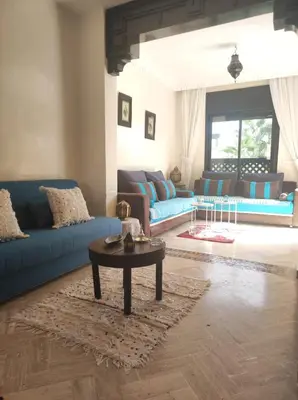 a living room with blue couches and a coffee table at Appart atlas resort in Marrakech