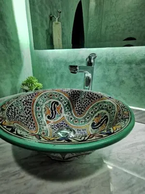 a bathroom sink with a snake design on it at Maison de standing - Médina de Marrakech in Marrakech