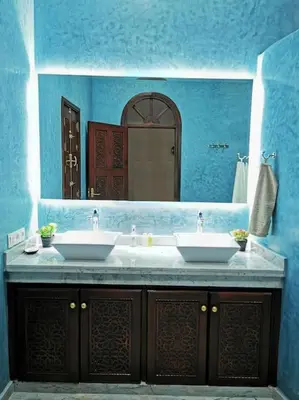 a blue bathroom with two sinks and a mirror at Maison de standing - Médina de Marrakech in Marrakech