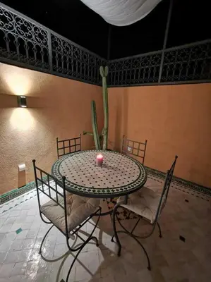 a table with chairs and a candle on top of it at Maison de standing - Médina de Marrakech in Marrakech