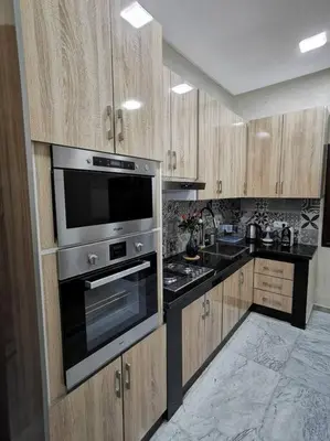 a kitchen with wooden cabinets and a stainless steel oven at Maison de standing - Médina de Marrakech in Marrakech