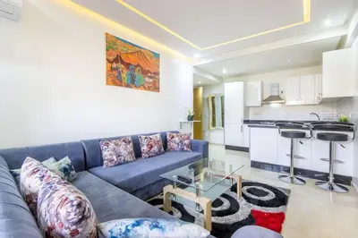 a living room with a blue couch and a kitchen at NEW! Plein Gueliz, terrasse, wifi in Marrakech