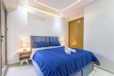 a bedroom with a blue bed in a white room at NEW! Plein Gueliz, terrasse, wifi in Marrakech