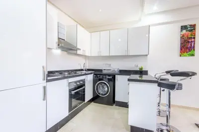 a kitchen with white cabinets and a dishwasher at NEW! Plein Gueliz, terrasse, wifi in Marrakech