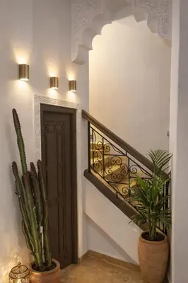 a staircase with two potted plants next to a door at RIAD JOUJ- Oasis privée avec bassin et SPA - kasbah in Marrakech