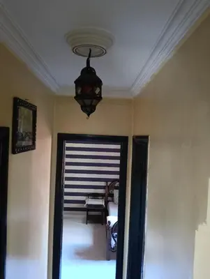 a chandelier hanging from a ceiling in a room at Au centre,Charmant appartement dans un quartier chic et calme, Très bon emplacement in Marrakech