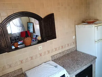 a kitchen with a counter and a white refrigerator at Au centre,Charmant appartement dans un quartier chic et calme, Très bon emplacement in Marrakech