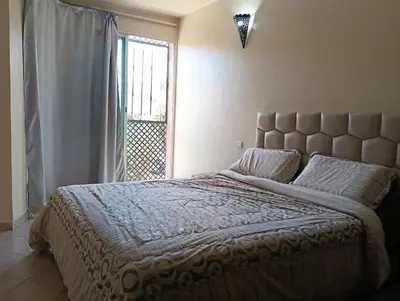 a bedroom with a large bed and a window at Au centre,Charmant appartement dans un quartier chic et calme, Très bon emplacement in Marrakech