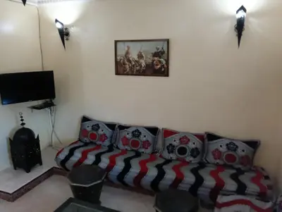 a living room with a couch and a painting on the wall at Au centre,Charmant appartement dans un quartier chic et calme, Très bon emplacement in Marrakech