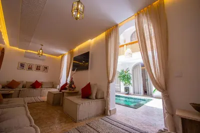 a living room with a couch and a pool at RIAD DAR BAYANE in Marrakech
