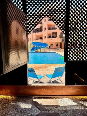 two blue chairs sitting in front of a swimming pool at Palmera de Marrakech in Marrakech