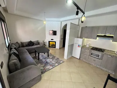 a living room with a couch and a kitchen at Palmera de Marrakech in Marrakech