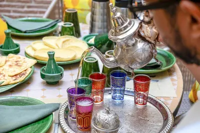 a table topped with colorful glasses and a teapot at Riad Kasbabouch - Breakfast - 10mn to Jamaa Al Fna in Marrakech