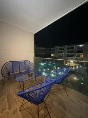 a room with a table and chairs on a balcony at Apartment pool marrakech in Marrakech