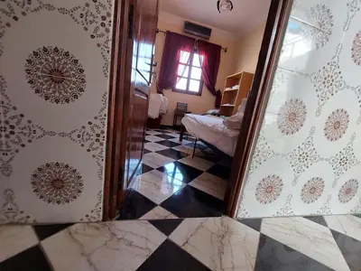 a room with a checkerboard floor and a mirror at Samsat Apartement House Marakech in Marrakech