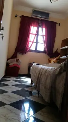 a bedroom with a bed and a window with purple curtains at Samsat Apartement House Marakech in Marrakech