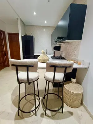 a kitchen with two bar stools and a counter at Cosy appartement au cœur de Gueliz in Marrakech