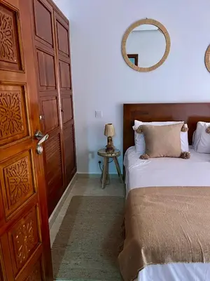 a bedroom with a bed and a mirror on the wall at Cosy appartement au cœur de Gueliz in Marrakech