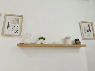 a shelf with vases and pictures on a wall at Cosy appartement au cœur de Gueliz in Marrakech