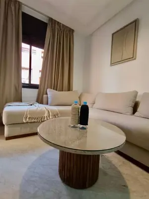 a living room with a table and a couch at Cosy appartement au cœur de Gueliz in Marrakech