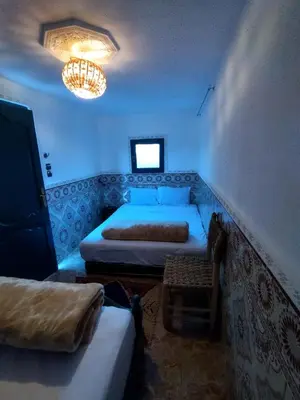 a room with two beds and a chandelier at Kesh apartment in Marrakech