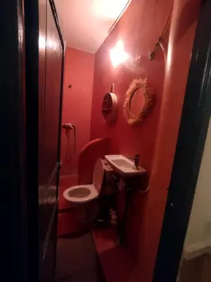 a red bathroom with a toilet and a sink at Kesh apartment in Marrakech
